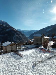 a snow covered roof of a building with mountains in the background at Ampio e grazioso trilocale con vista panoramica in Chiesa in Valmalenco