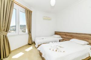twee bedden in een kamer met een raam bij Villa White Dream in Kalkan +30 foto's