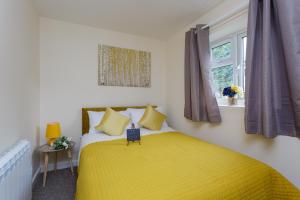 um quarto com uma cama amarela e uma janela em Luxury Burgess Apartments close to Soton General Hospital em Southampton