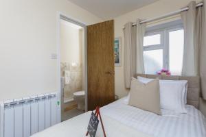 a bedroom with a bed and a bathroom with a toilet at Luxury Burgess Apartments close to Soton General Hospital in Southampton