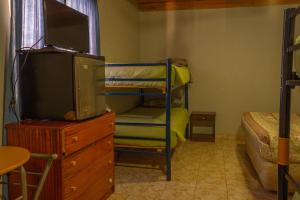 1 dormitorio con litera y vestidor con TV en La Casa del Sol Naciente en San Pedro de Atacama