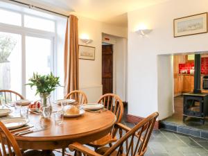 a dining room with a table and chairs and a fireplace at Littleham Court Cottage in Bideford