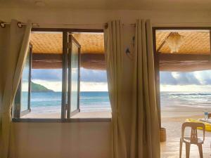 een kamer met een raam met uitzicht op het strand bij Fisherman's Cottage El Nido in El Nido