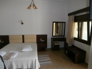 a bedroom with a white bed and a mirror at Villa Barouti in Koinyra