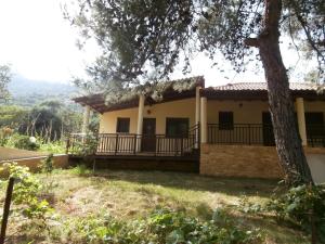 a house with a balcony and a tree at Villa Barouti in Koinyra