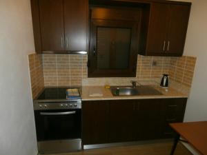 a kitchen with brown cabinets and a stove and a sink at Villa Barouti in Kinira
