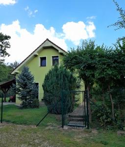 ein gelbes Haus mit einem Tor davor in der Unterkunft Apartmán u Šimků in Třeboň