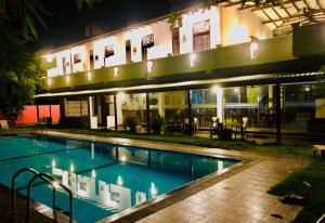 a swimming pool in front of a building at night at Saman Resort Yala in Tissamaharama
