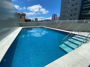 a large swimming pool on the roof of a building at Flat Unitá Homestay in Praia Grande