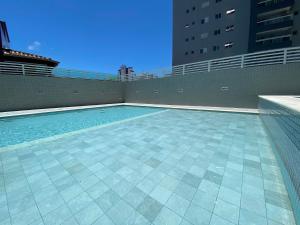 a swimming pool on the side of a building at Flat Unitá Homestay in Praia Grande