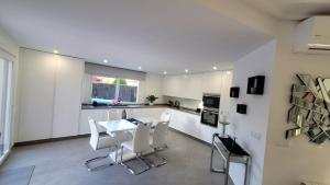 a kitchen with white cabinets and a table and chairs at VILLA PALMITO Mar Menor Golf in Torre-Pacheco