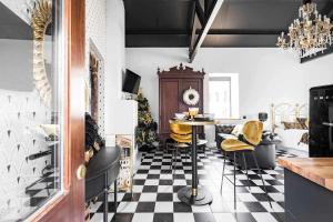 a kitchen with a table and chairs on a checkered floor at La Suite Años 20. Bañera, chimenea y terraza. in Corcubión