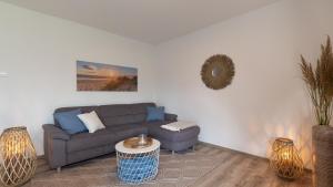 ein Wohnzimmer mit Sofa und Tisch in der Unterkunft Ferienhaus Sonneneck am Harkebrügger See mit Sauna in Barßel