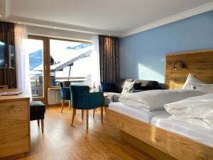 a bedroom with two beds and a table and chairs at Hotel Menning ***S in Oberstdorf