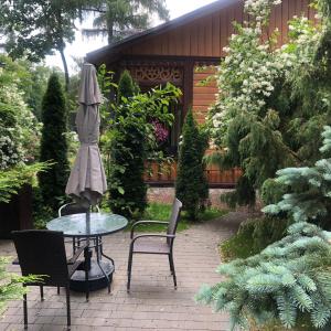 un patio con mesa, sillas y sombrilla en Atelier Foto Lipowa - Apartamenty, en Nałęczów