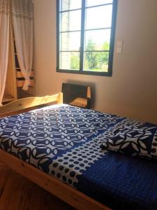 a bedroom with a bed with a blue comforter and a window at Villa élégante à Biscarrosse avec piscine privée in Biscarrosse +49 photos