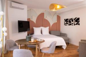 una camera d'albergo con letto, tavolo e sedie di Yuna Blanche - Serviced Apartments a Parigi