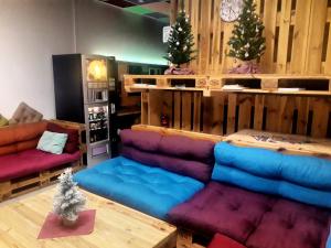ein Wohnzimmer mit Sofas und Weihnachtsbäumen in der Unterkunft FOX BOX I Capsule Apt in Dresden