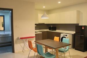 a kitchen with a wooden table and chairs at Suasana Suites Homestay10 JB TOWN in Johor Bahru