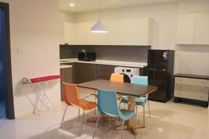a kitchen with a wooden table and chairs at Suasana Suites Homestay10 JB TOWN in Johor Bahru +7 photos