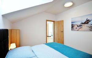 a bedroom with a bed and a painting on the wall at Villa Blanca - Apartamenty in Grzybowo