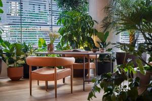 a table and chairs in a room with plants at Pendry Manhattan West in New York