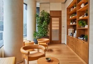 a room with plants and chairs in a building at Pendry Manhattan West in New York