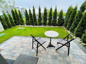 a patio with a table and two chairs and a garden at Apartament pod Dębowcem - Starzyńskiego Valley in Bielsko-Biala