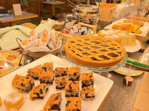 una mesa con un pastel y una mesa de comida en Alledolomiti Boutique Lake Hotel - Adults friendly en Molveno