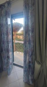 een kamer met een glazen schuifdeur naar een patio bij Sweet Home in Lido di Ostia