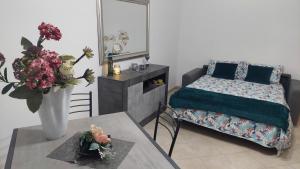 een slaapkamer met een bed en een tafel met een vaas met bloemen bij Sweet Home in Lido di Ostia