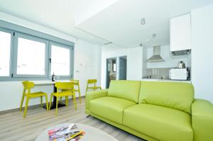 a living room with a green couch and a kitchen at IVY HOUSE in Seville