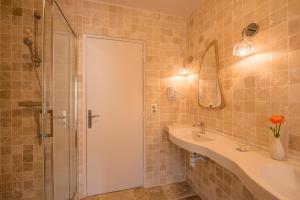 a bathroom with a sink and a shower at Le Central Boutique Hôtel in Beaune
