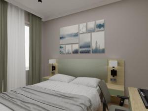 a bedroom with a bed and a desk with two lamps at SULO Bautino Hotel in Bautino