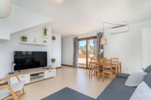 ein Wohnzimmer mit einer Couch, einem Fernseher und einem Tisch in der Unterkunft Casa Kaliste in Puerto Calero