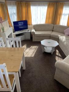 a living room with a couch and a table at Lake District Static Caravan Lakeside Cumbria in Millom