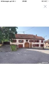 a large white building with a large garage at la ferme de manu in Saulxures