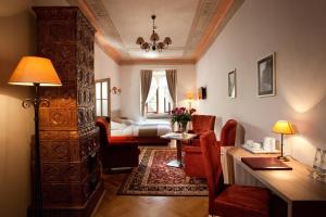 ein Wohnzimmer mit einem Schreibtisch und ein Zimmer mit einem Bett in der Unterkunft Hotel Santi in Krakau