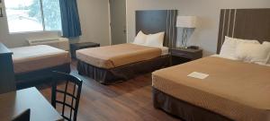 pokój hotelowy z 2 łóżkami i stołem w obiekcie Rodeway Inn Kalkaska w mieście Kalkaska