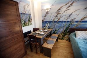 een eetkamer met een tafel en een bank bij Das Apartmenthaus Klambauer Frauenkirchen Thermennähe St Martins Therme in Frauenkirchen