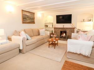 a living room with a couch and a fireplace at Kims Cottage in Penzance