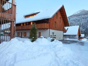 a building with a pile of snow in front of it at Apartments Maison in Kranjska Gora