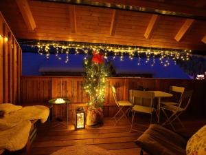 une véranda avec un arbre de Noël et des lumières dans l'établissement Apartments Maison, à Kranjska Gora