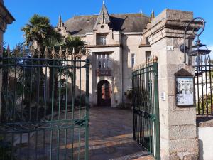 einen Eingang zu einem alten Haus mit einem Tor in der Unterkunft Hôtel De La Barbacane in Tiffauges