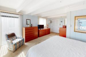 a bedroom with a bed and a tv and a chair at White Sands Village 30 in Ocean City