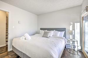a white bedroom with a large bed and a window at Hot Tub and Mtn Views Silverthorne Escape! in Silverthorne