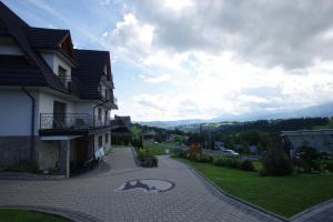 ゾンプにあるPOKOJE KOZICAの車道にクマの絵が飾られた家