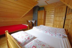 ゾンプにあるPOKOJE KOZICAの木造キャビン内のベッドルーム1室(ベッド2台付)