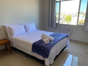 una camera da letto con un letto con un cuscino sopra di Apto a beira mar no Centro - WIFI 200MB - TV Smart - Cozinha equipada - Portaria 24h - Ar condicionado a Rio das Ostras