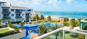 ピランジ・ド・スーにあるQavi - Flat em Resort Beira Mar na Praia de Búzios #Corais303のスイミングプールと海を望むリゾートです。